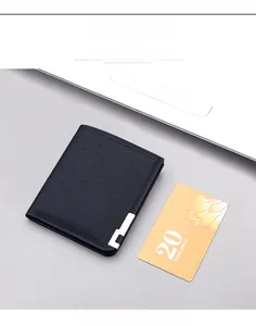 Close-up of slim black canvas wallet with metal corner on a laptop surface