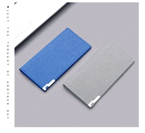 Detail view of thin canvas wallets in blue and grey with metal corner accents and card slots