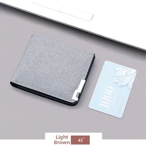 Dettaglio del portafoglio bifold in tela grigia con clip a L argentata e bordo liscio