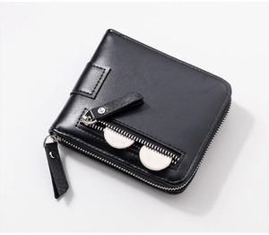 Detail of black leather wallet showing a functional side zipper pocket with silver coins