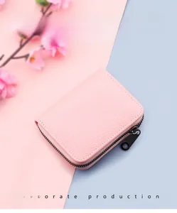 Close-up of pink lychee pattern leather card holder with grey metal zipper detail
