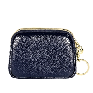 Detail der marineblauen Leder-Geldbörse mit doppelten Gold-Reißverschlüssen und Herzanhänger