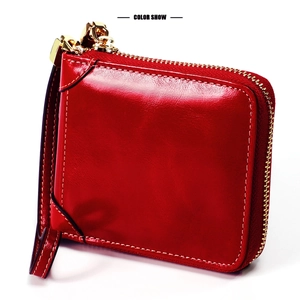 Détail du portefeuille en cuir huilé rouge avec fermeture éclair dorée et coutures