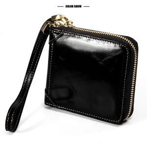 Détail du portefeuille en cuir noir ciré avec zip doré et surpiqûres contrastées