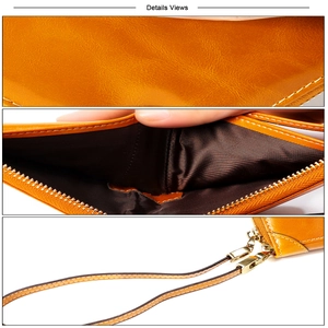 Détail macro du portefeuille en cuir ciré gingembre avec zip doré et dragonne assortie