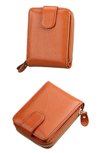 Macro shot of orange pebble leather wallet showing texture and zipper detail