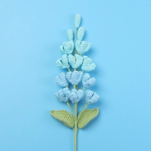 Detailed close-up of handmade crochet gradient blue lilac flowers and green stem