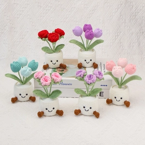 Detail of handmade crochet flower potted plants with cute smiling faces and tiny legs