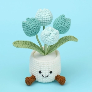 Close-up of handmade crochet blue tulip potted plant with a cute smiley face on the base