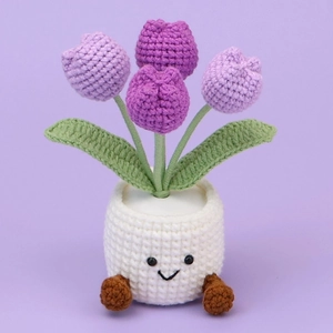 Detailed view of handmade purple crochet tulip in a white pot with a cute smiling face