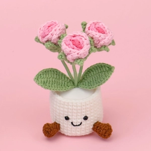 Handmade crochet pink roses in a white pot with a cute face and brown legs