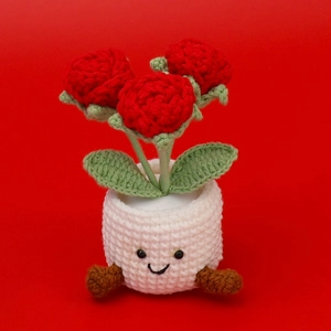 Detailed knit texture of handmade crochet red roses in a cute white smiling pot decor