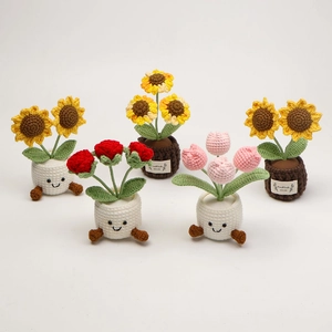 Detailed macro view of handmade crochet sunflower and tulip flower pots with cute feet