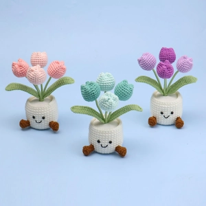 Handmade crochet tulip flower pots in pink, blue, and purple with cute smiling faces