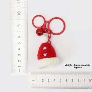 Detailed view of handmade knitted Christmas hat keychain with red and white snowflake pattern