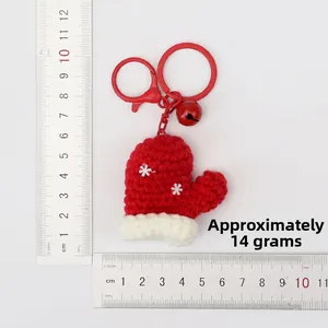 Detailed macro view showing a 5.5cm red crochet Christmas glove charm with scales