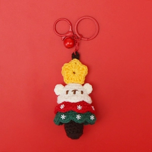 Detail of handmade crochet Christmas tree pendant with red metal ring and small bell