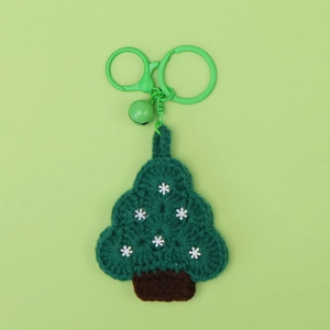 Detailed view of hand-crocheted green Christmas tree keychain with white snowflake motifs