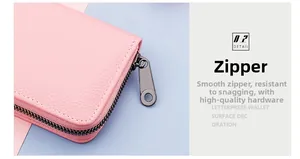 Close-up of pink litchi grain leather card holder with smooth grey metal hardware zipper