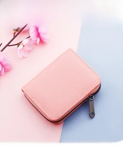 Detail of pink lychee textured leather card holder with secure metal zipper closure