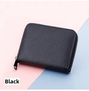Close-up of black lychee grain leather card holder with silver zipper on bicolor background
