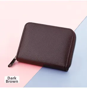 Detail of dark brown card holder with litchi grain leather texture and silver zipper