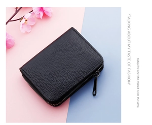 Close-up of black litchi pattern leather card holder with secure metal zipper closure