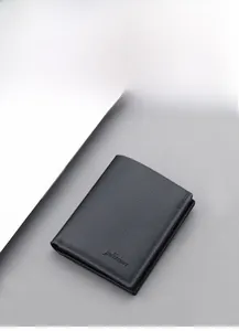 Detailed close-up of a black lychee grain leather wallet with minimalist logo and stitching