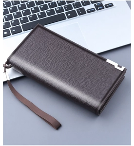 Detail of dark brown pebble leather clutch with metal corner and wrist strap