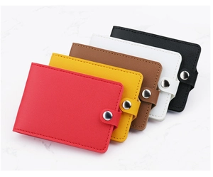 Detail view of colorful snap-closure card holders in premium litchi-grain leather texture