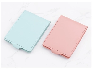 Detail view of pink and blue PU leather card holders with neat stitching on marble surface
