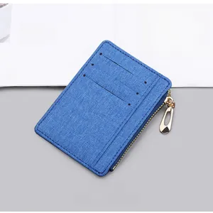 Close-up of blue canvas card holder with three card slots and golden zipper