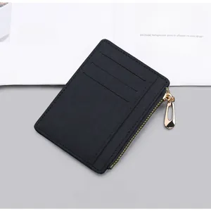 Slim black canvas card holder featuring three slots and a gold zipper detail on textured fabric