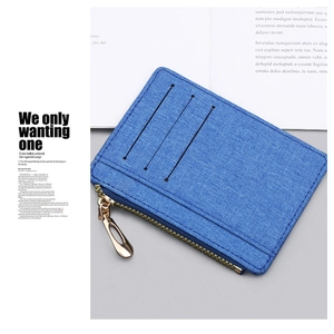 Detailed close-up of blue canvas card holder with three slots and golden zipper