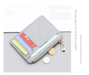 Detailed view of gray canvas card holder with multiple slots and metal zipper closure