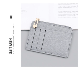 Close-up of grey canvas card holder featuring three slots and golden zipper detail