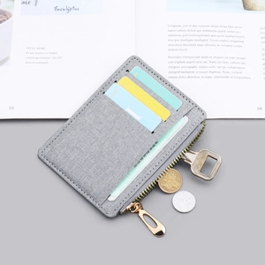 Slim grey canvas card holder for men and women featuring multiple slots and a zipper pocket