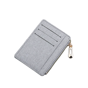 Slim gray canvas card holder featuring three slots and a gold zipper closure