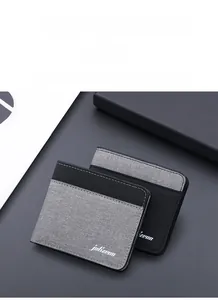Gros plan du portefeuille fin en toile avec coutures contrastées et logo détaillé