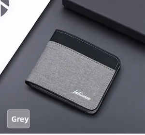 Détail du portefeuille en toile grise et cuir noir avec surpiqûres blanches