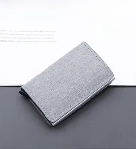 Macro detail of slim RFID blocking grey canvas wallet with automatic pop-up mechanism