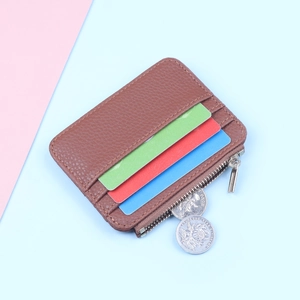 Detailed view of brown leather card holder with three card slots and a metal side zipper