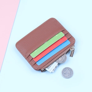 Close-up of brown litchi leather card holder with three slots and a metal zipper compartment