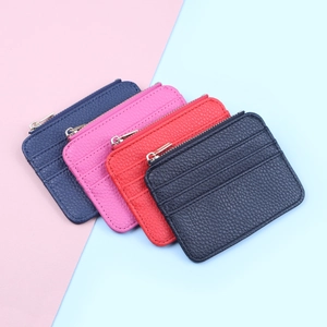 Flat lay of four colorful textured PU leather zipper card holders on a dual-tone background