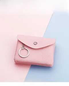 Detailed view of pink lychee leather coin purse with silver snap button and keychain ring