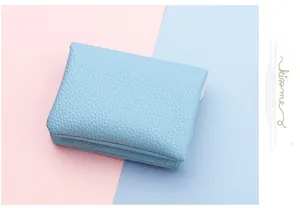 Close-up of light blue pebble grain coin purse showing fine stitching and leather texture