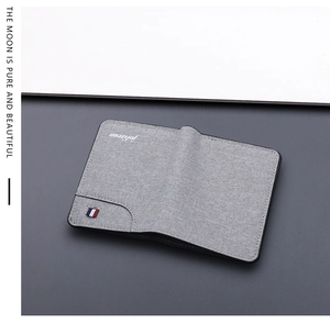 Close-up of gray fabric bi-fold wallet with fine twill texture and tri-color ribbon detail