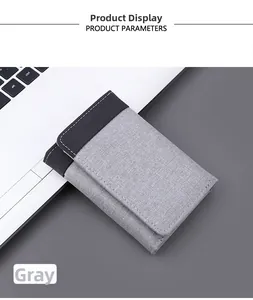 Detail view of tri-fold canvas wallet in grey with contrast stitching on laptop keyboard