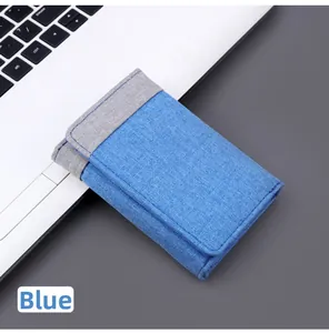 Close-up of short tri-fold canvas wallet in blue and grey contrast colors on a laptop