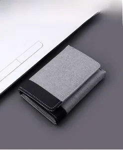 Detailed close-up of gray and black canvas tri-fold wallet with neat stitching detail